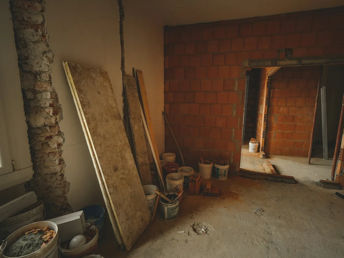 Interno in demolizione con pareti in laterizio e materiali da cantiere